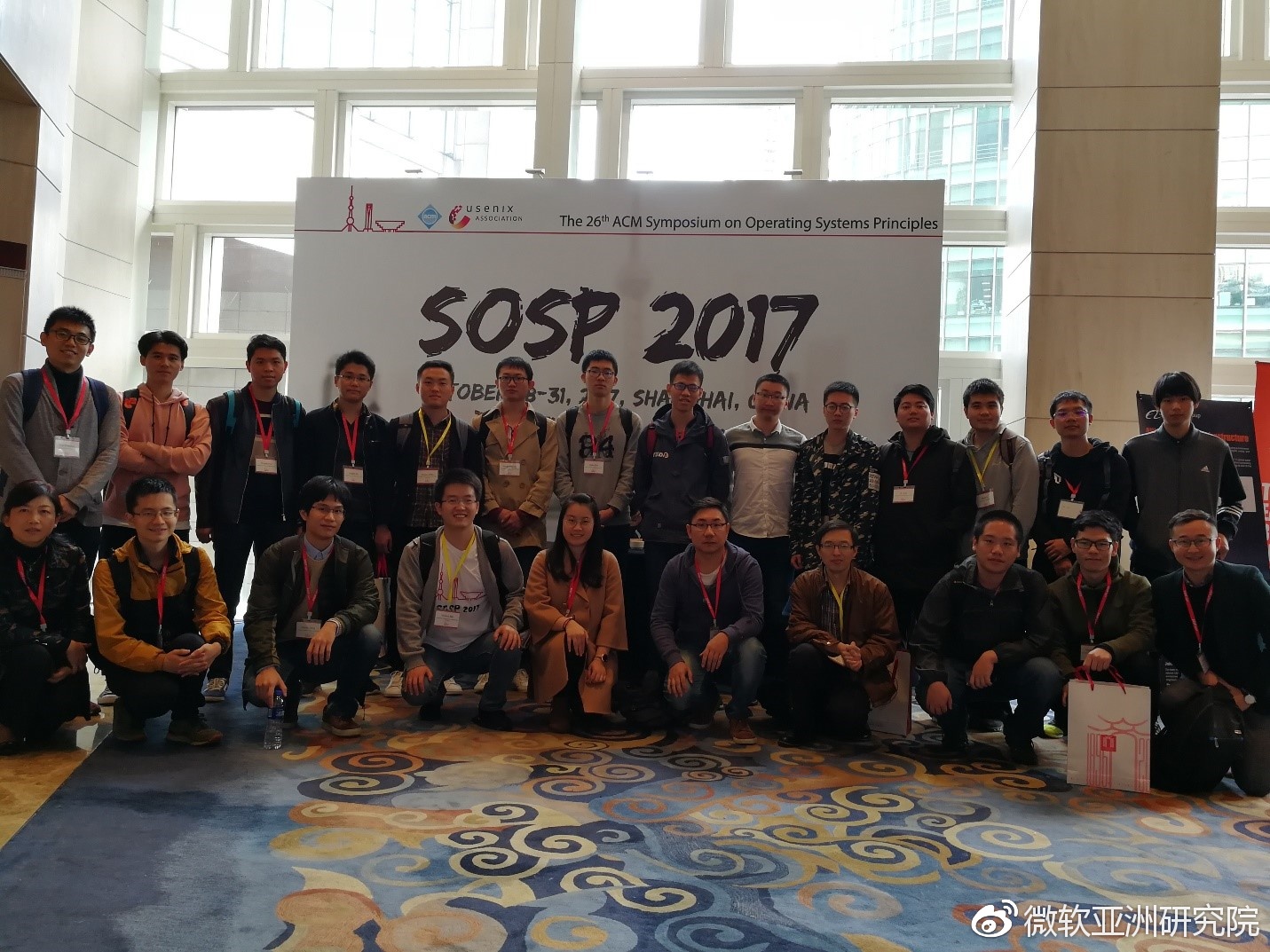 Group photo of teachers and students from the University of Science and Technology of China at SOSP, including the co-first author of KV-Direct published by the Systems Group of Microsoft Research Asia, Bojie Li (third from right in the back row), Zhenyuan Ruan (first from right in the back row), and the Systems Group interns from Microsoft Research Asia who participated in the SOSP Student Research Competition, Yuanwei Lu (second from right in the front row), Tianyi Cui (second from left in the front row), and Ge Fei Zuo (seventh from left in the back row).
