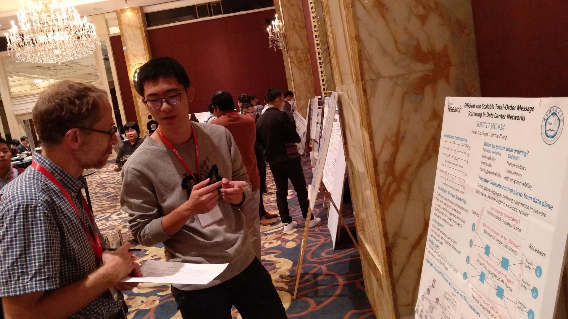 Microsoft Research Asia intern Zuo Gefei presents his research results to SIGOPS Chair Professor Robbert van Renesse at the SOSP Student Research Competition (SRC), which won the silver medal in the undergraduate group.