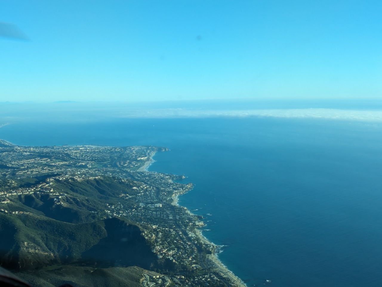 Green mountains, blue sky, and the sea