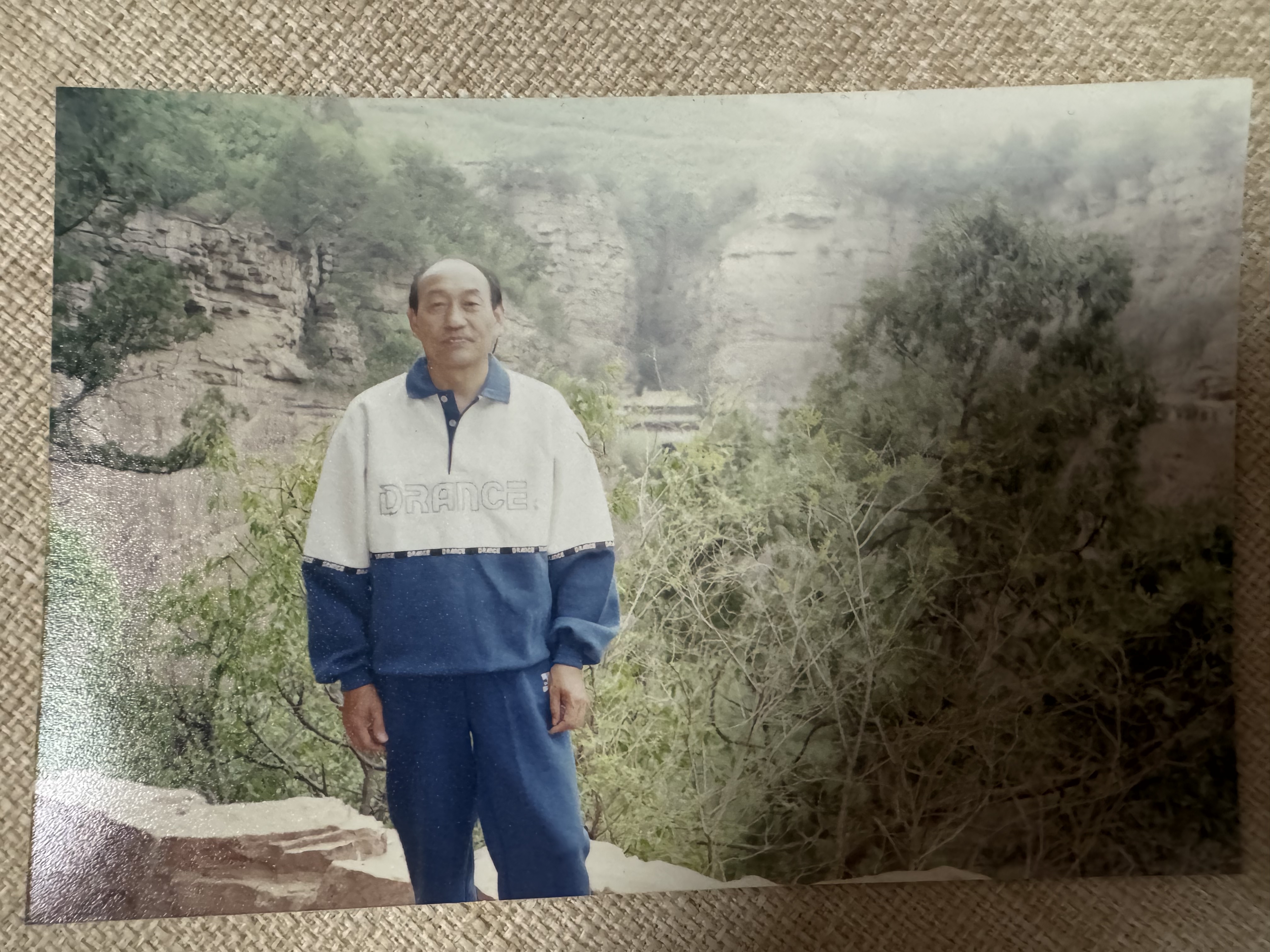 A photo of my grandfather climbing a mountain after retirement, kept in the family album